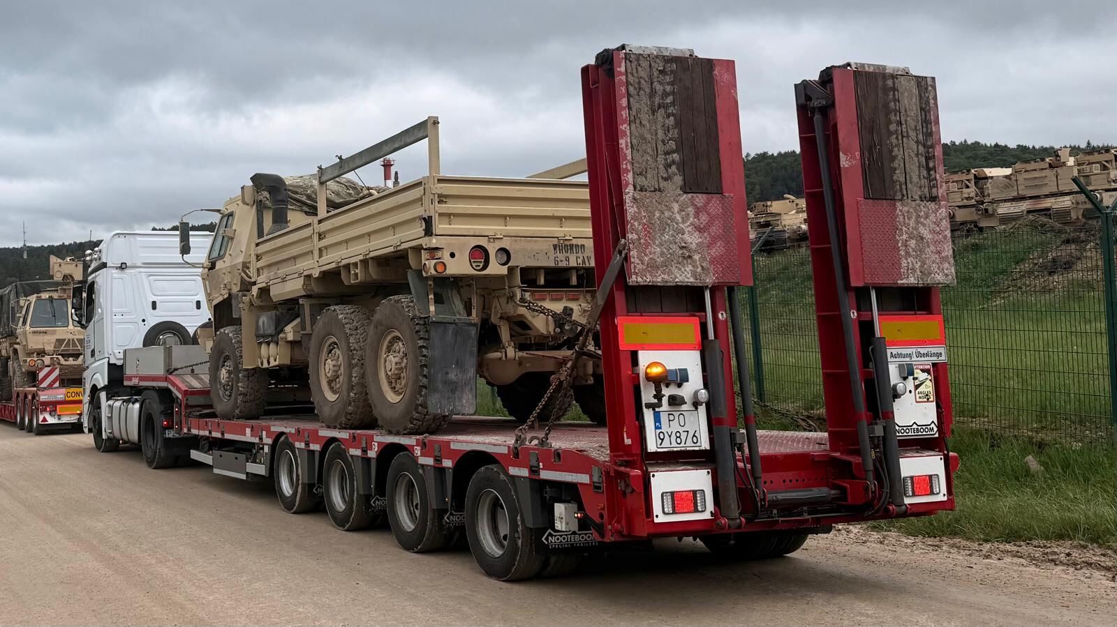 Tactical truck loaded on a lowloader with hydraulic ramps raised