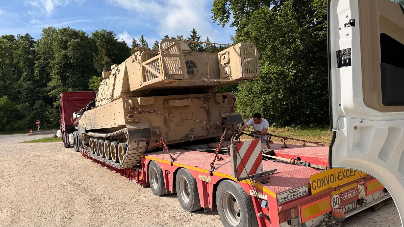 Armoured recovery vehicle chained down on a lowloader trailer